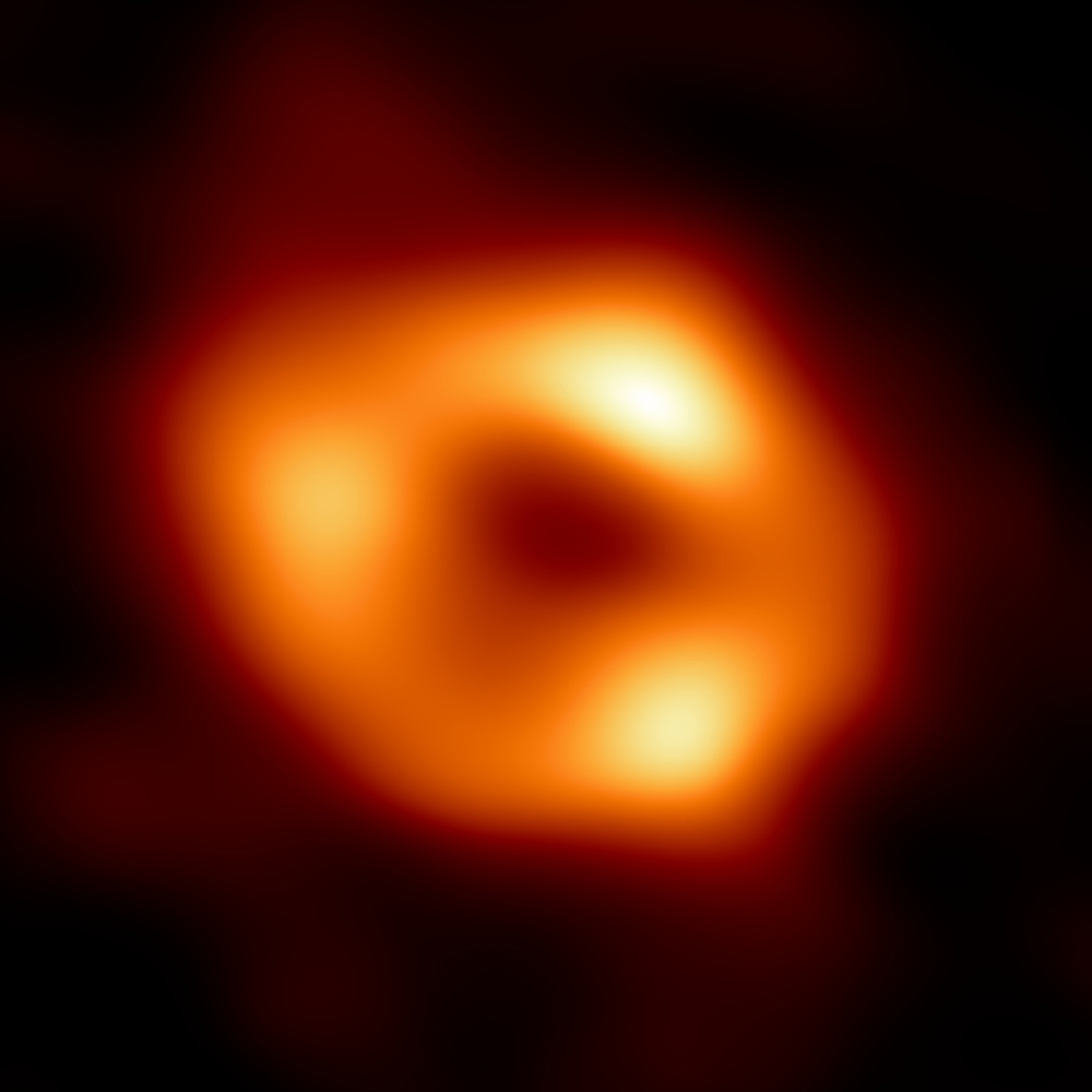 This is the first image of Sgr A*, the supermassive black hole at the centre of our galaxy. It’s the first direct visual evidence of the presence of this black hole. It was captured by the Event Horizon Telescope (EHT), an array which linked together eight existing radio observatories across the planet to form a single “Earth-sized” virtual telescope. The telescope is named after the event horizon, the boundary of the black hole beyond which no light can escape.   Although we cannot see the event horizon itself, because it cannot emit light, glowing gas orbiting around the black hole reveals a telltale signature: a dark central region (called a shadow) surrounded by a bright ring-like structure. The new view captures light bent by the powerful gravity of the black hole, which is four million times more massive than our Sun. The image of the Sgr A* black hole is an average of the different images the EHT Collaboration has extracted from its 2017 observations.  In addition to other facilities, the EHT network of radio observatories that made this image possible includes the Atacama Large Millimeter/submillimeter Array (ALMA) and the Atacama Pathfinder EXperiment (APEX) in the Atacama Desert in Chile, co-owned and co-operated by ESO is a partner on behalf of its member states in Europe.